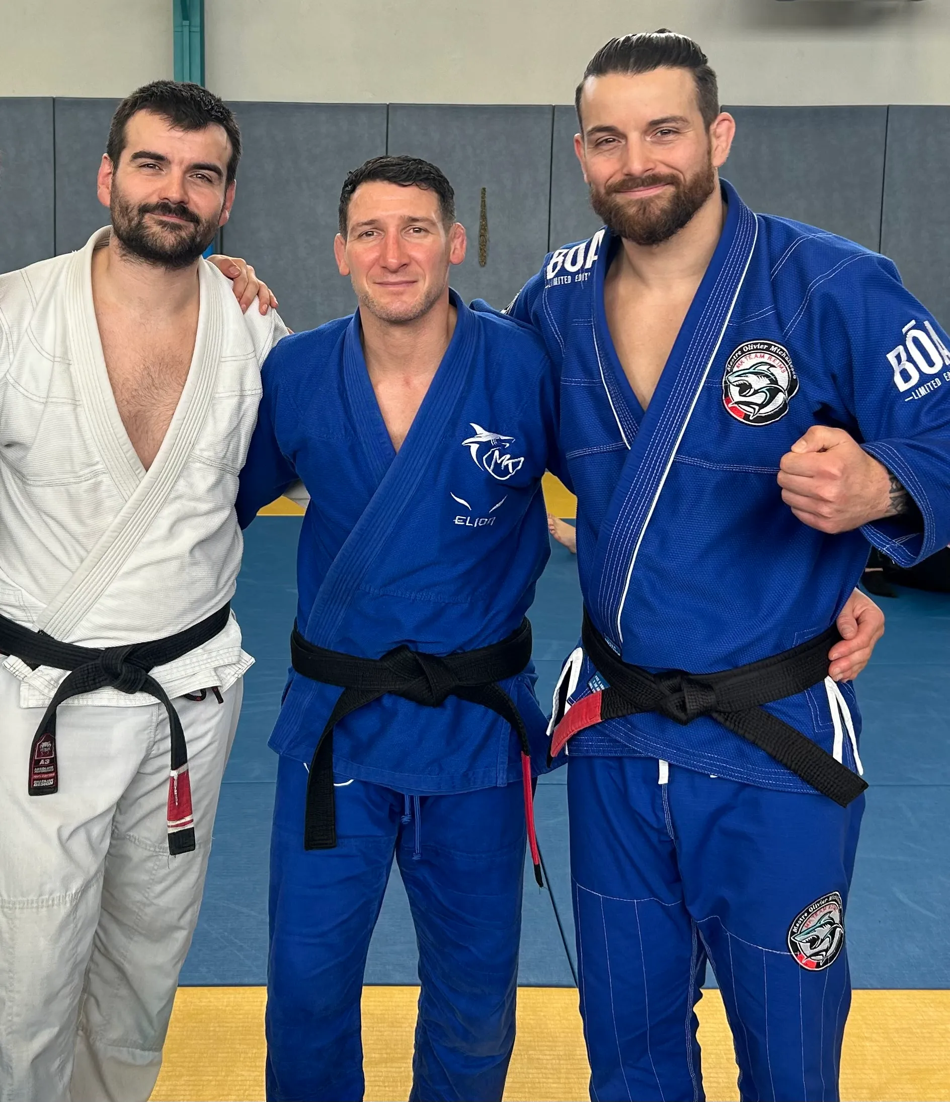 Rémi et David Thomas en kimono avec un professeur de la MK Team, ceintures noires